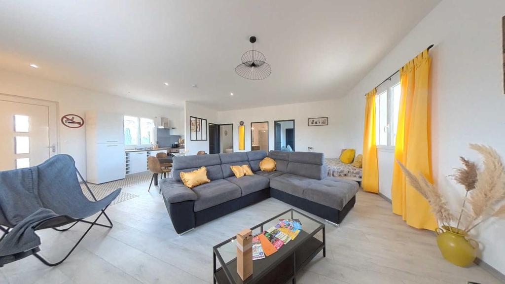 un salon avec un canapé gris et une table dans l'établissement Spacious 2 bedroom Apartment with Garden Near Pezenas, à Nézignan-lʼÉvêque