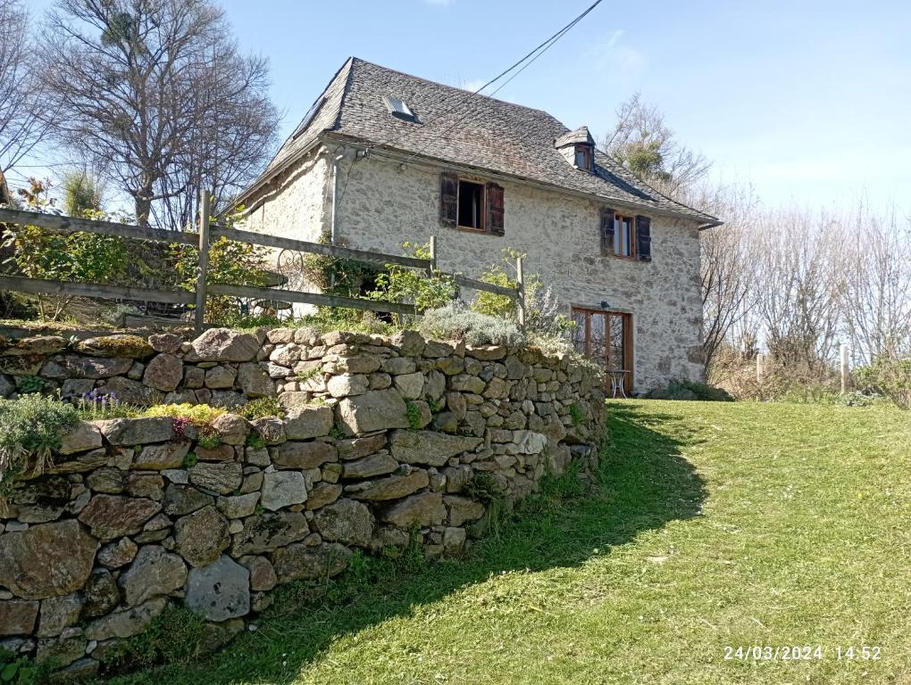 una pared de piedra frente a una casa de piedra en Roseland, retraite calme en pleine nature en Saint-Girons