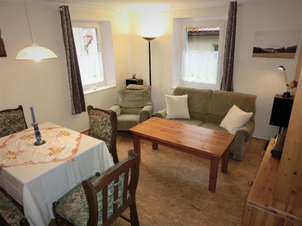 ein Wohnzimmer mit einem Tisch und einem Sofa in der Unterkunft Wohnung in Schönberg in Lauf an der Pegnitz