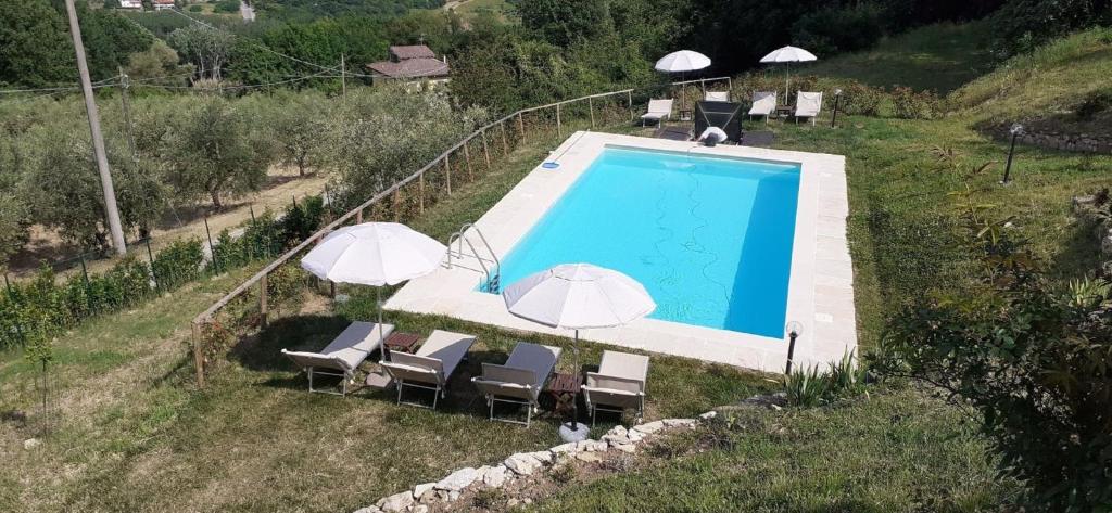 una imagen de una piscina con sombrillas y sillas en Appartement in Rignano Sull'arno mit Schöner Terrasse, en Rignano sullʼArno
