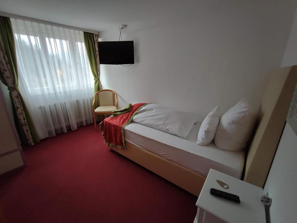 a hotel room with a bed and a window at Room in Guest room - Comfortable single room with shared bathroom and kitchen in Forbach