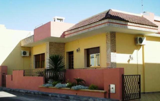 una casa gialla e rossa con recinzione di Salento Al Mare a Taviano