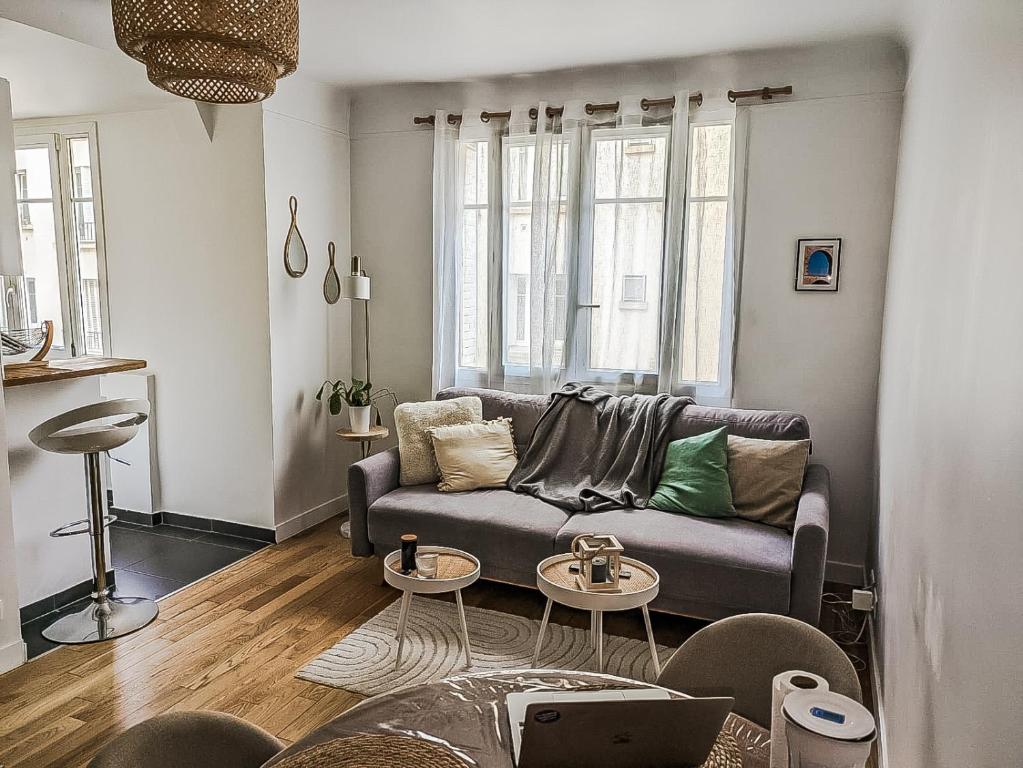 een woonkamer met een bank en 2 tafels bij HbyB - 1BR - Coeur Boulogne in Boulogne-Billancourt