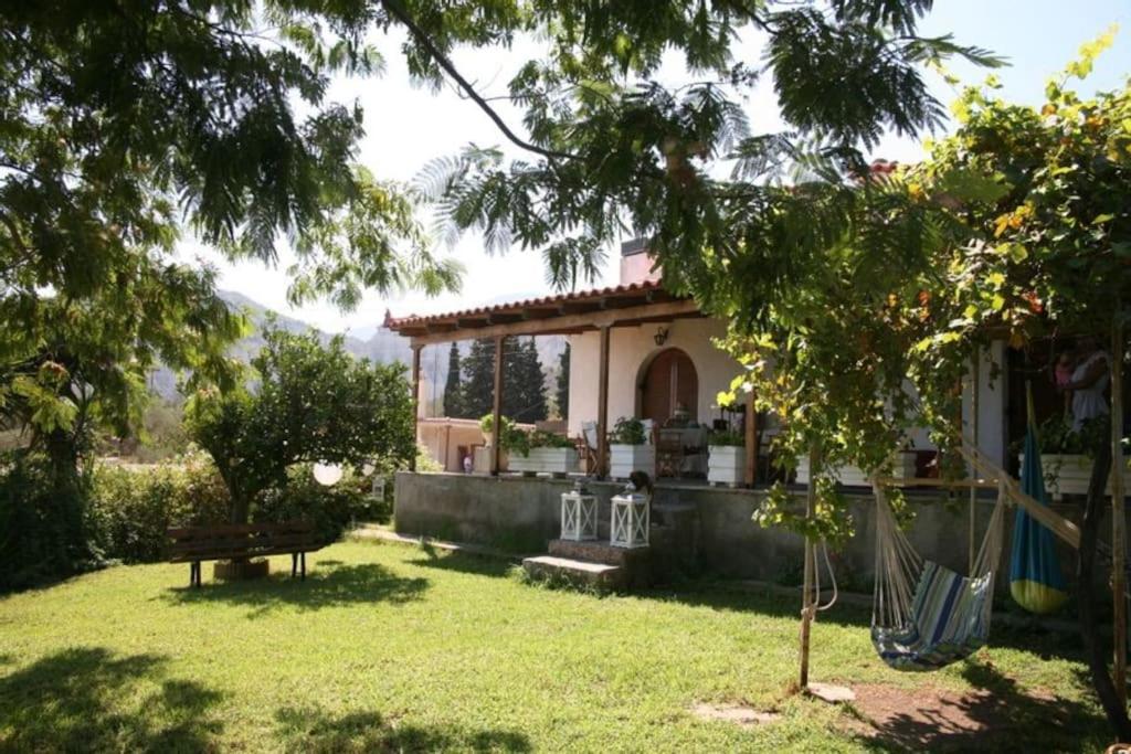 a house in a yard with a yard at Beekeeper's house by the beach with boat & bikes. in Liyiá