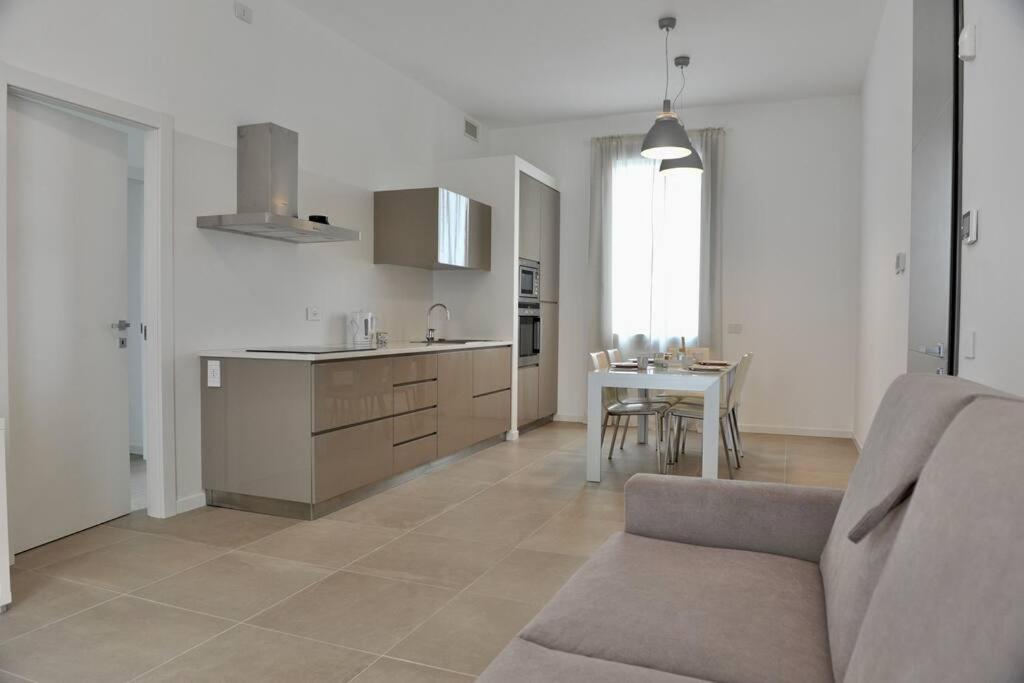 cocina y sala de estar con sofá y mesa en Appartamento Bartolomeo Colleoni, en Cavernago