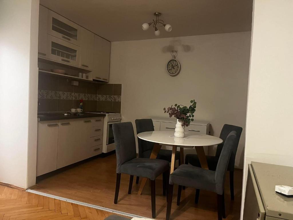 een keuken met een tafel en stoelen en een keuken met een aanrecht bij Stan na dan in Šid