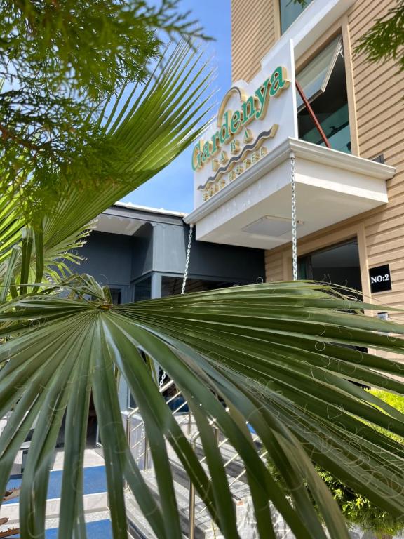 un palmier devant un bâtiment dans l'établissement Gardenya Lara Suit Hotel, à Antalya