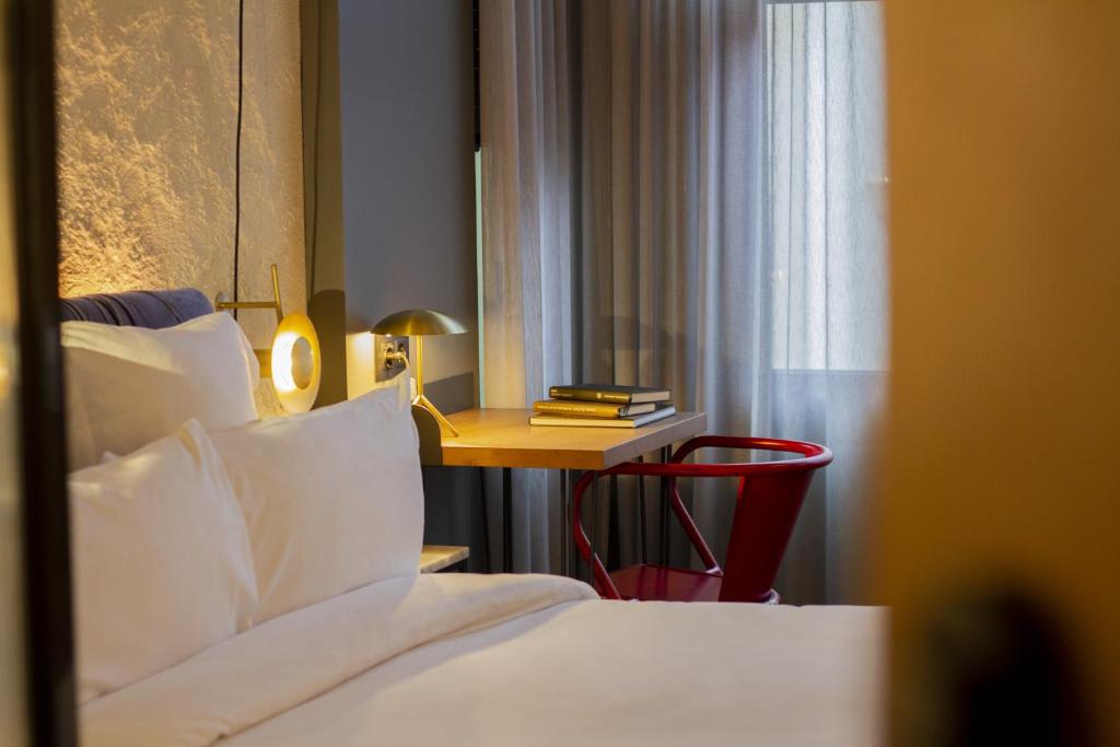 a hotel room with a bed and a table with a lamp at Letoh Letoh San Sebastián in San Sebastián