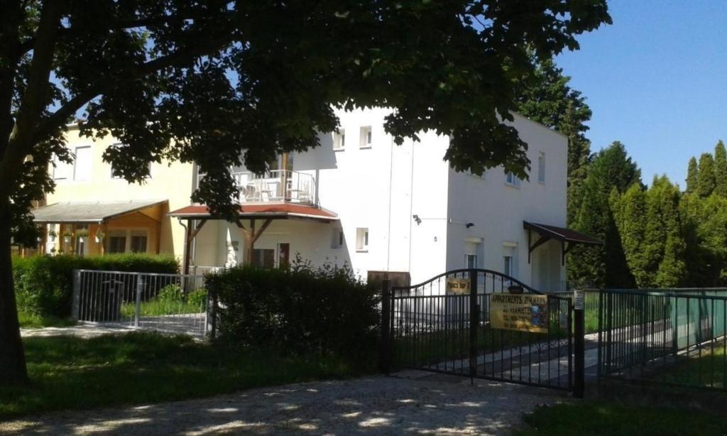 een wit gebouw met een poort ervoor bij Wohnung in Bükfürd mit Garten in Bükfürdő