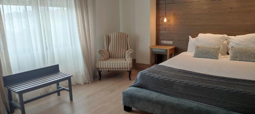 アビラにあるHotel Sercotel Cuatro Postesのベッドと椅子付きのホテルルーム