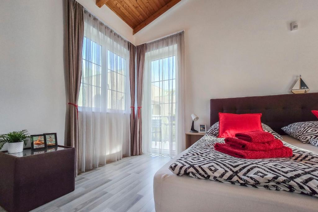 um quarto com uma cama com almofadas vermelhas em A104 Apartman em Siófok