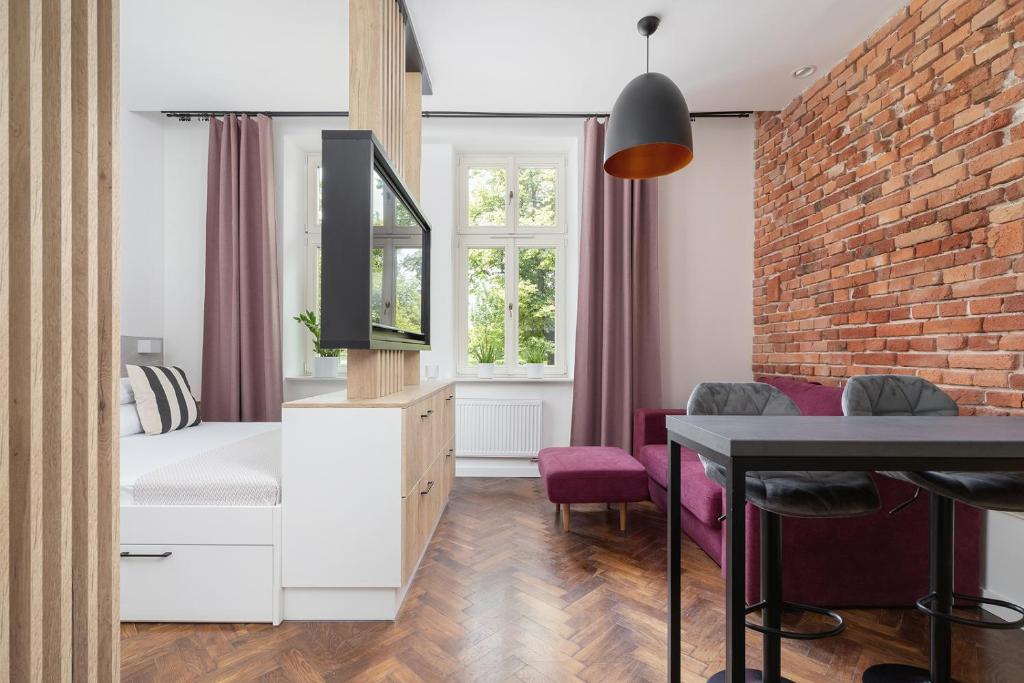 a bedroom with a bed and a brick wall at Kazimierz District - Dietla 21 - Studio Apartment in Krakow