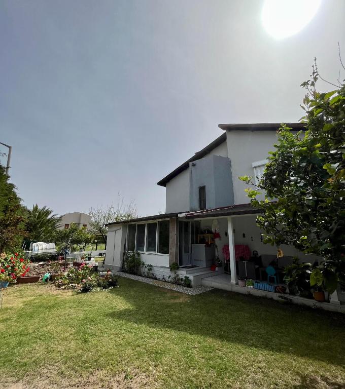 a white house with a yard in front of it at Villa 19 Apart Otel in Ilıca