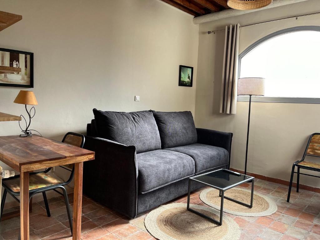 un salon avec un canapé et une table dans l'établissement T1 Au pied du Garlaban 30 minutes de Cassis, à Roquevaire