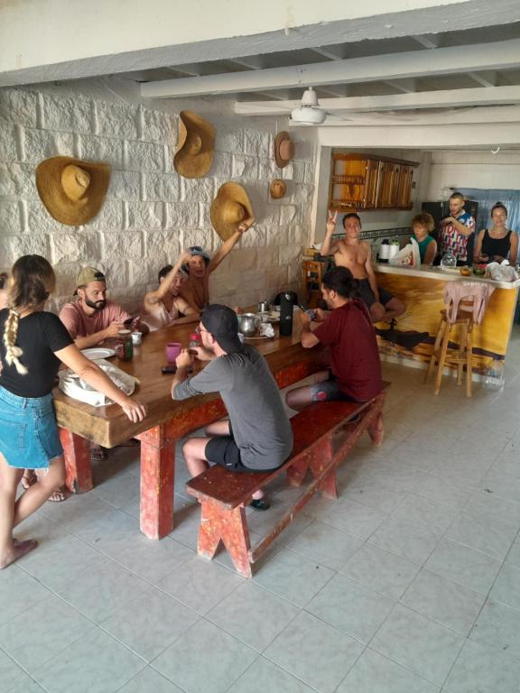 Taida Hostel Rincon del Mar في Rincón: مجموعة من الناس يجلسون على الطاولات في المطعم