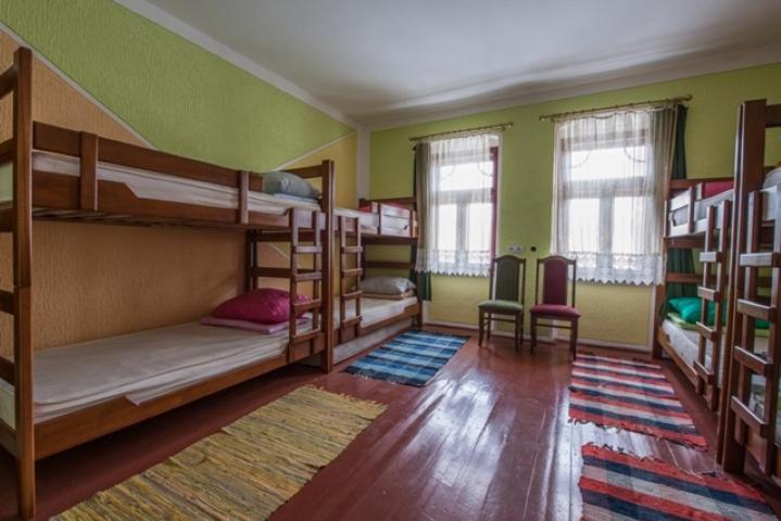 a room with three bunk beds and a rug at Edukativ Szállás in Skorenovac