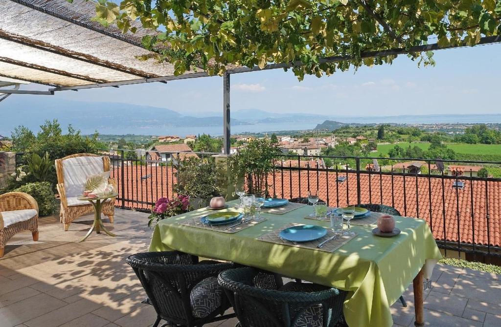 una mesa con un mantel verde en el patio en Ferienwohnung für 6 Personen ca 100 qm in Puegnago sul Garda, Gardasee Westufer Gardasee, en Castello
