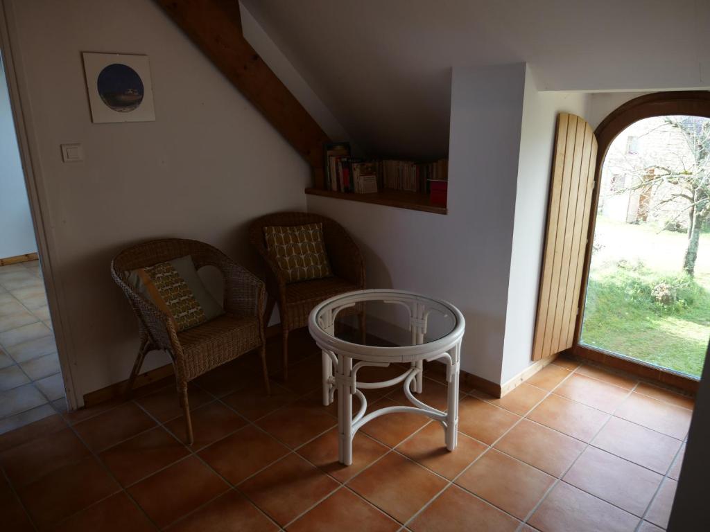 a room with a table and two chairs and a window at Gîte de l&#39;Hirondelle bleue in Brech