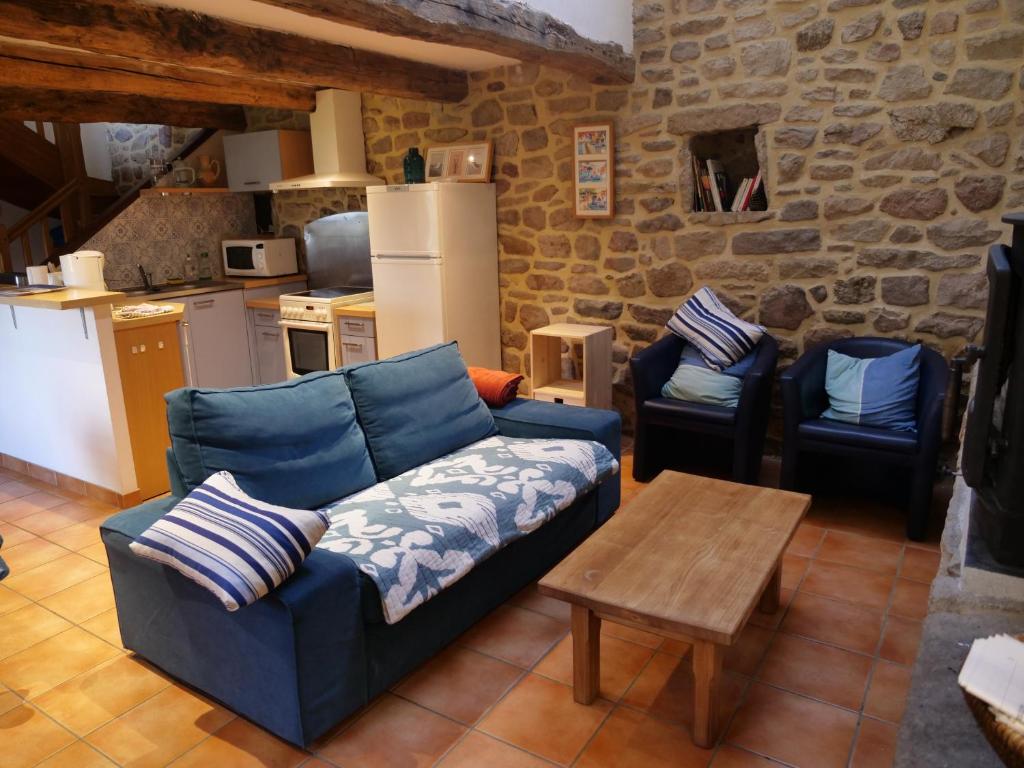a living room with a blue couch and two chairs at Gîte de l&#39;Hirondelle bleue in Brech
