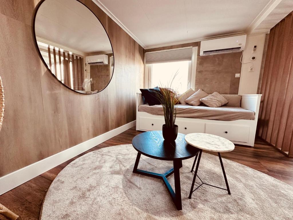 a room with a bed and a mirror and a table at Amsterdam Boathouse in Aalsmeer