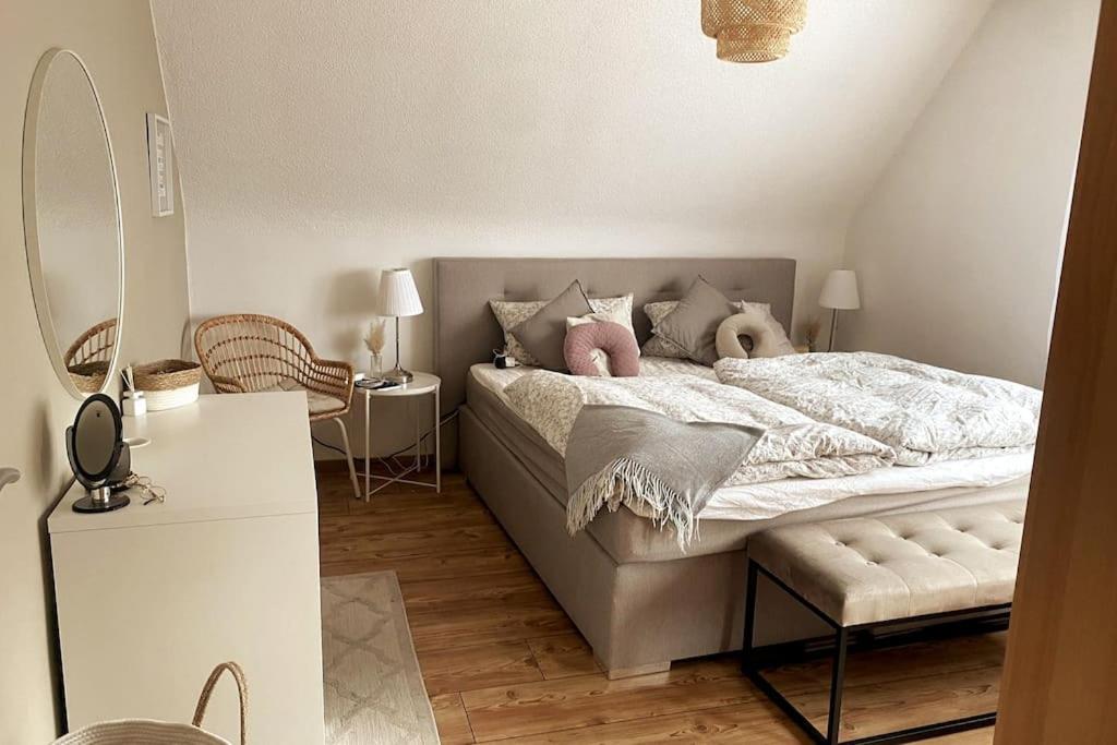 Wunderschönes 2 Zimmer Apartment inkl. Parkplatz في Asbach: غرفة نوم مع سرير مع وسادتين ورديتين
