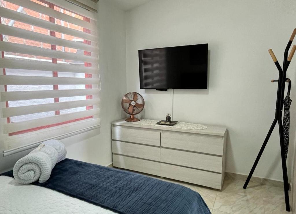ein Schlafzimmer mit einem Bett und einem TV an der Wand in der Unterkunft CASA BONITA SALENTO - Suite para parejas o Alojamiento en Grupos in Salento
