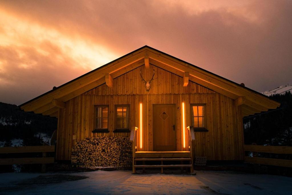 una cabaña con la puerta abierta en la nieve en Jagdhütte mit Kaminofen und Sauna en Lachtal