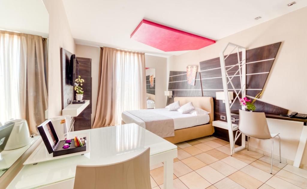ジュアン・レ・パンにあるホテル ヴィラ デルザのベッドとデスクが備わるホテルルームです。