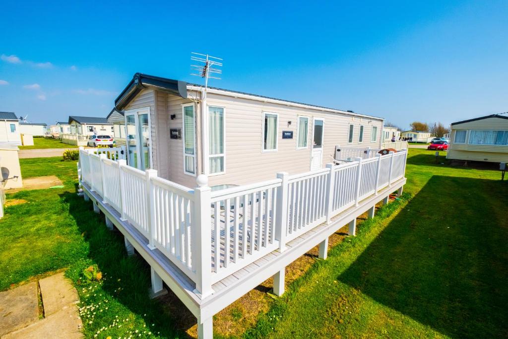 a white mobile home with a white deck at MP639 - Camber Sands Holiday Park - 3 Bedroom - Sleeps 8 - Large gated decking - Close to facilities in Camber