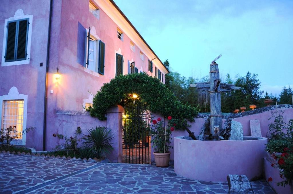 een roze gebouw met een fontein ervoor bij Großes Ferienhaus in Bargecchia mit Privatem Pool in Corsanico-Bargecchia
