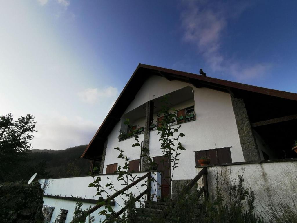 Una casa blanca con ventanas en un lateral. en Ferienwohnung für 4 Personen 1 Kind ca 50 qm in Borzonasca, Ligurien Provinz Genua, en Borzonasca