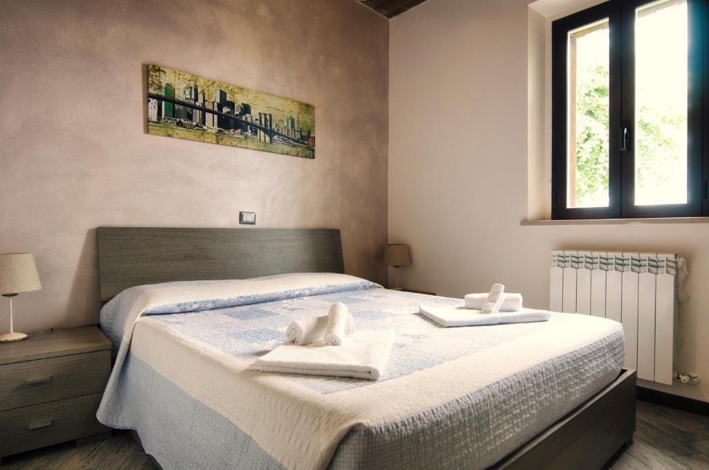 1 dormitorio con 2 toallas blancas en una cama en Agriturismo B&B La Cerasa, en Fabriano