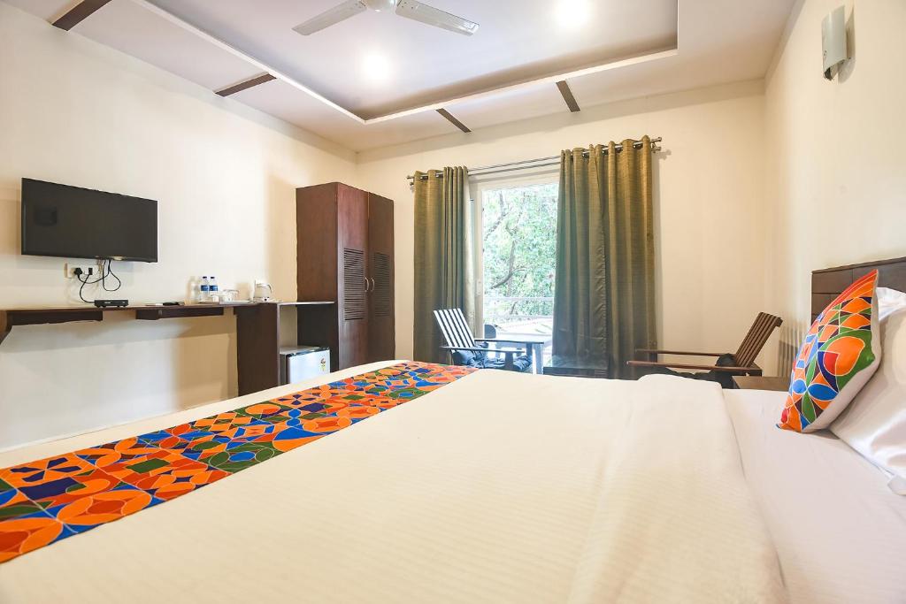 a bedroom with a large white bed and a television at La Volga by Turtle Retreat in Morjim