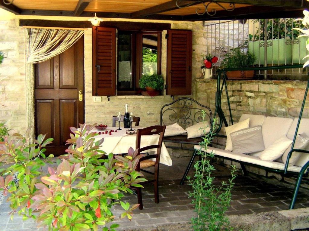 d'une terrasse avec une table, un banc, une table et des chaises. dans l'établissement Ferienwohnung Flieder, à Cagli