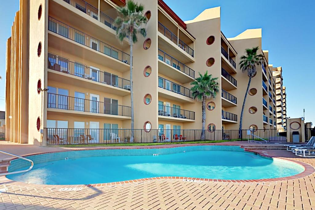 a swimming pool in front of a building at Suntide II in South Padre Island