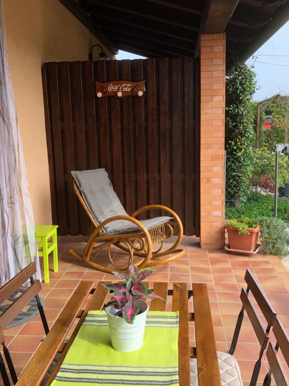 eine Terrasse mit einer Bank und einem Stuhl auf einer Terrasse in der Unterkunft Casa Zaza' in Premariacco