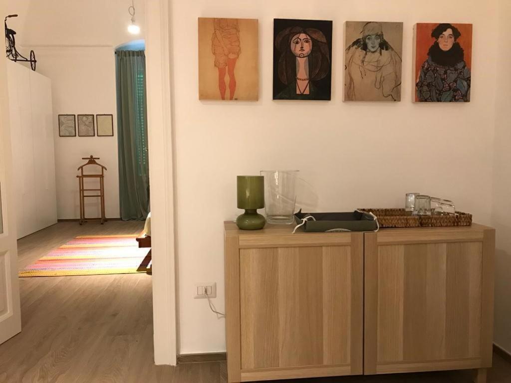 Zimmer mit einem Holzschrank mit Bildern an der Wand in der Unterkunft #pazzadite in Molfetta