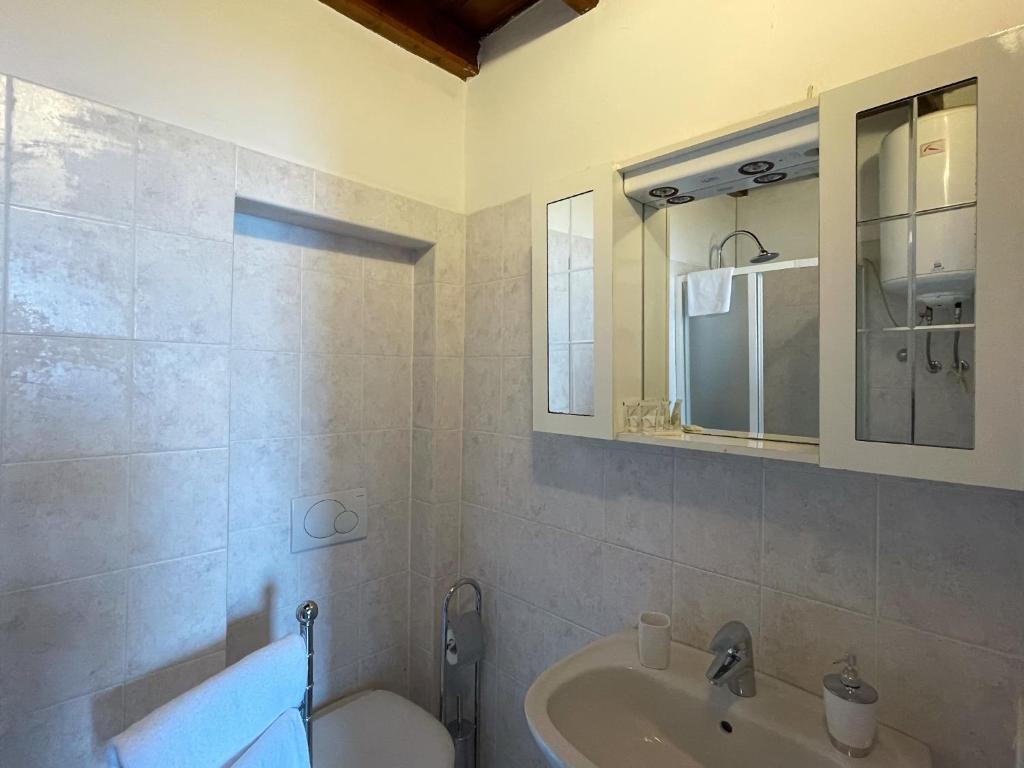 y baño con lavabo, aseo y espejo. en renzo e Lucia lake view apartment, en Oliveto Lario