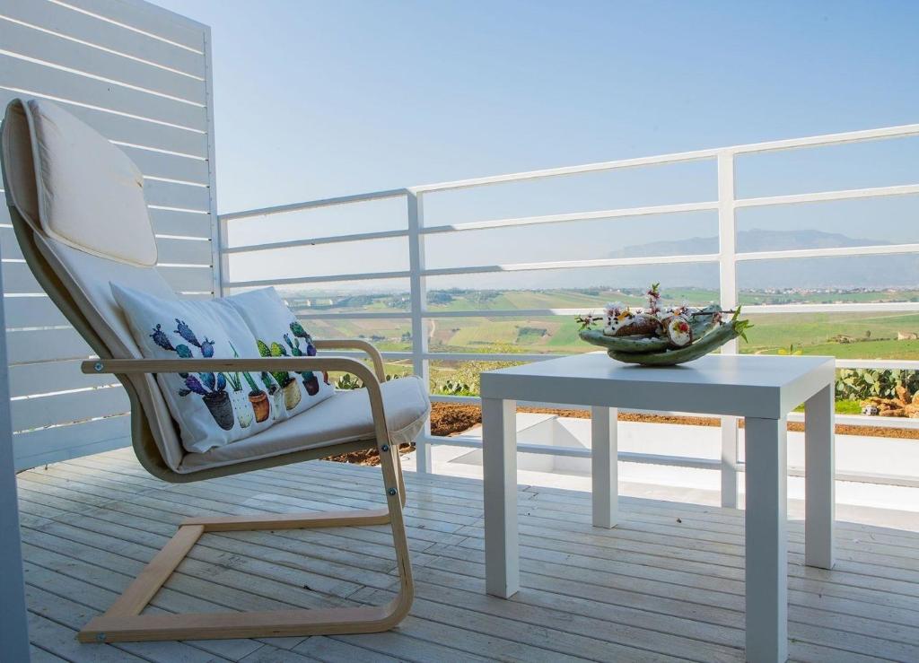 uma cadeira e uma mesa numa varanda com vista em Ferienhaus in Partinico mit Privatem Pool em Balestrate