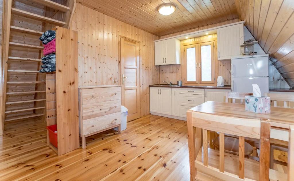 una cocina con suelo de madera y una mesa en una cabaña en Domki w Krasnobrodzie, en Krasnobród