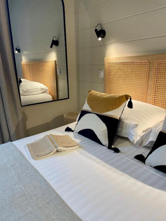 a bedroom with a large bed with a mirror at Hôtel Les Costans, The Originals Relais in Perros-Guirec
