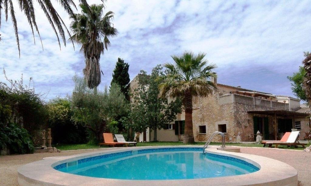 a swimming pool in front of a house with palm trees at Ferienwohnung für 2 Personen ca 25 m in Sencelles, Balearen Mallorca in Sencelles