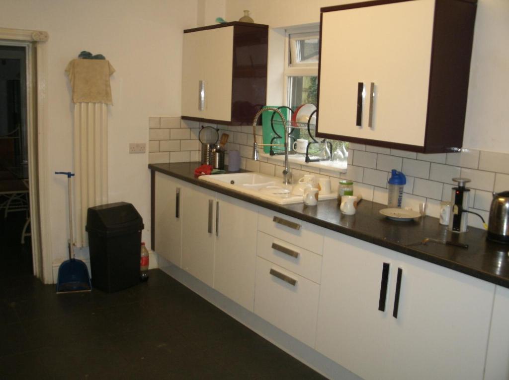 a kitchen with white cabinets and a sink and a window at Contractors House Edgbaston in Birmingham