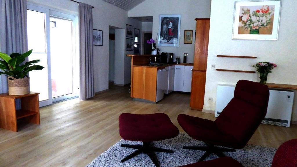 a living room with two chairs and a kitchen at Appartment Reitz - Urlaub in der Heimat der Brüder Grimm in Fritzlar