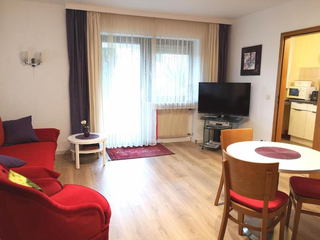 uma sala de estar com um sofá vermelho e uma mesa em Apartment Gala, ruhige Lage, stadtnah em Bad Kissingen