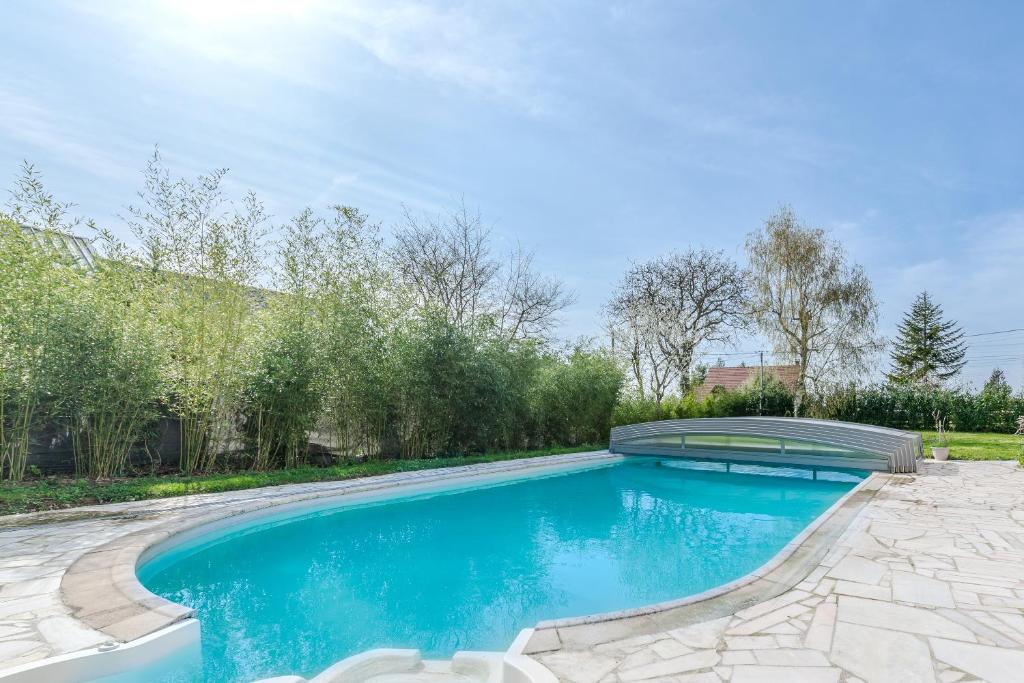 une piscine dans une cour avec un patio dans l'établissement Blue Villa near Disneyland Paris, à Chalifert