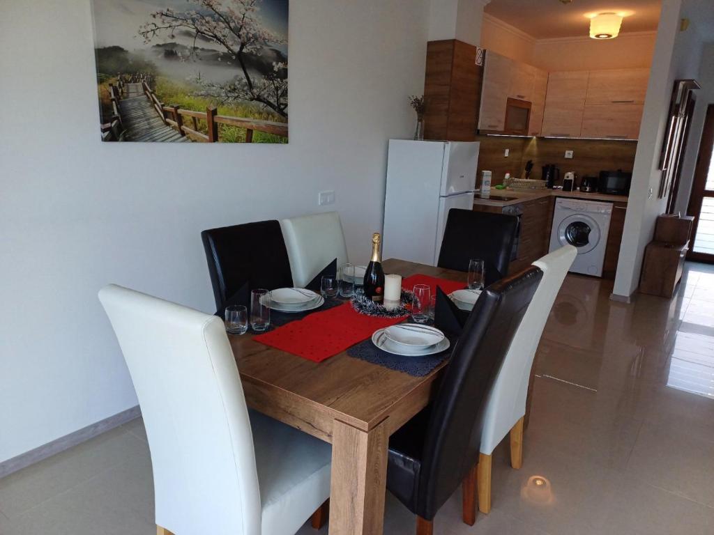 un tavolo in legno con sedie bianche e una sala da pranzo di Lighthouse 3 bedrooms villa F36 a Balchik
