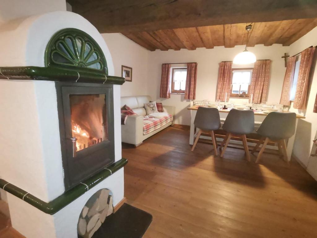 a living room with a fireplace and a dining room at Landhaus Schusterfranz in Passail