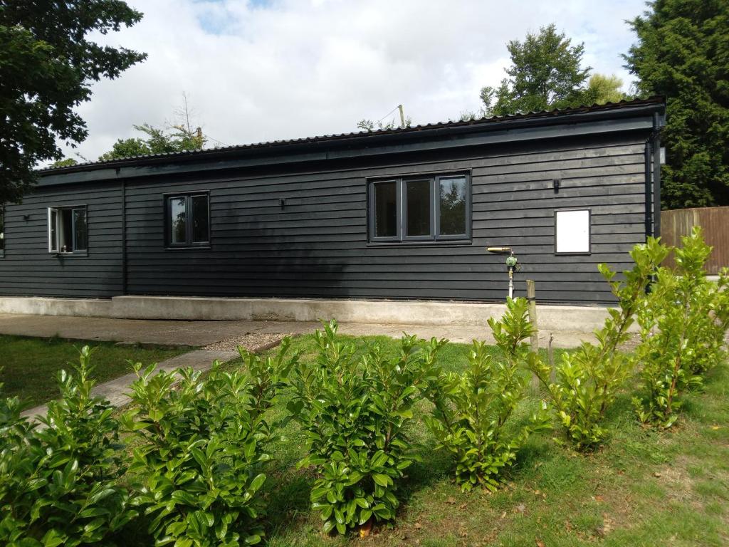 a black tiny house in a garden at Chapter Farm Cottages in Canterbury