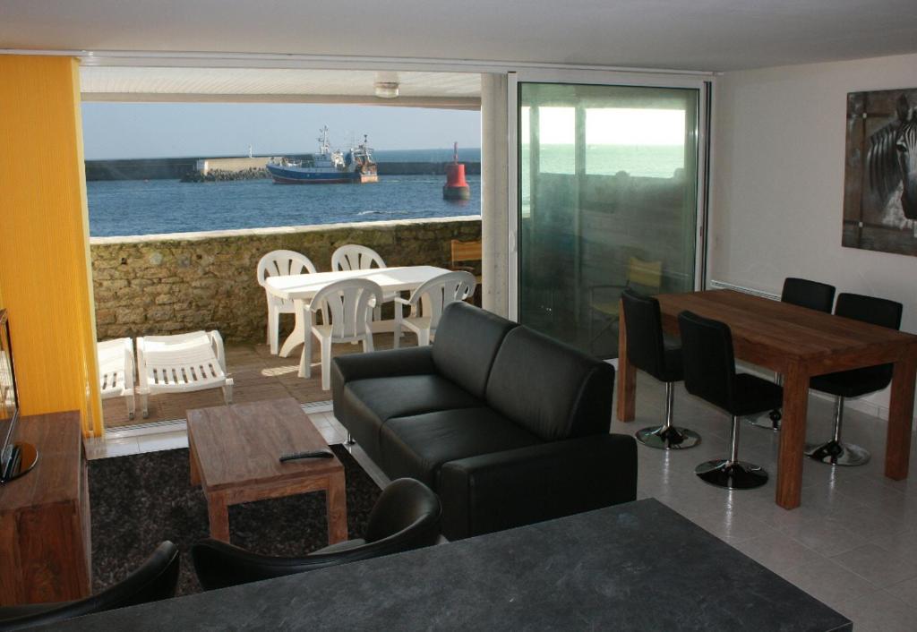 Una sala de estar con un sofá y vista al mar. en Le pieds dans l'eau - Direct sur la mer, en Le Guilvinec